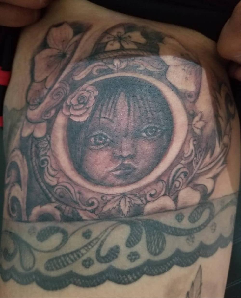 Child portrait in ornate frame tattoo by Marcelo Tattoos Bronx