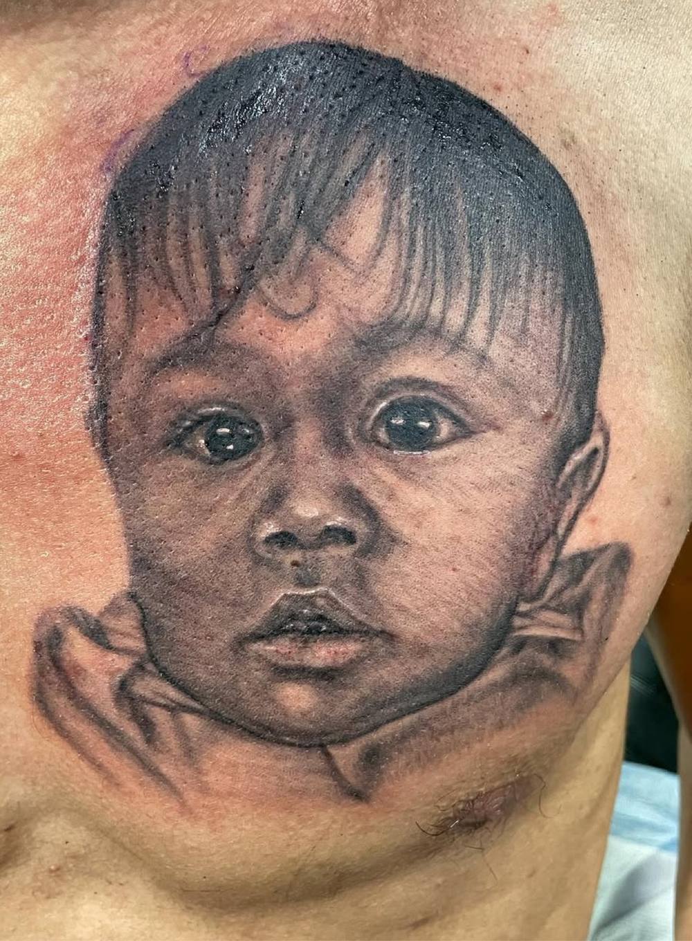Baby portrait chest tattoo by Marcelo Tattoos Bronx NY